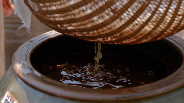 Traditional Korean Soybean Paste Filtered through a Sieve into a Pot