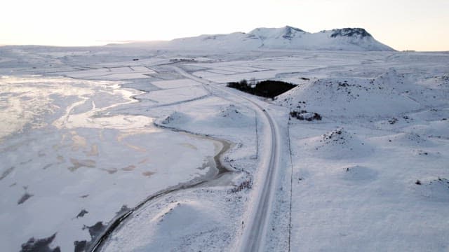 Snowy landscape with mountains and a road
