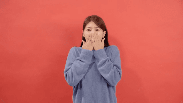 Woman relieved after being startled in front of a red background