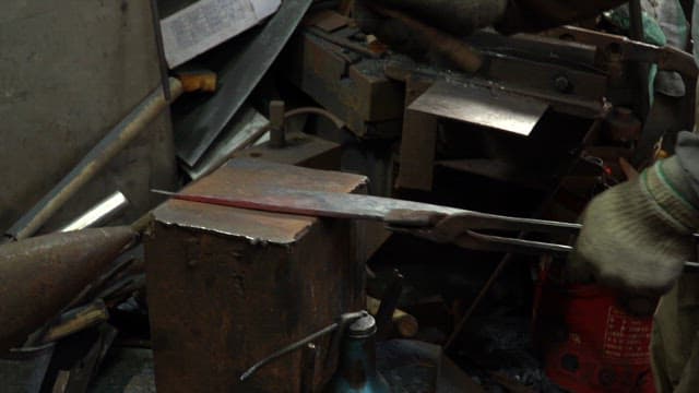 Hammering a metal blade on an anvil