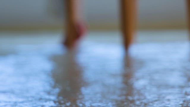 Person Sitting on a Chair with Rainwater on the Floor