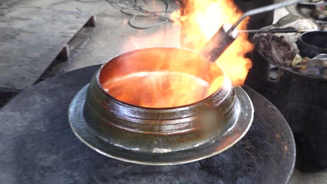 Using a torch to heat a cast iron cauldron