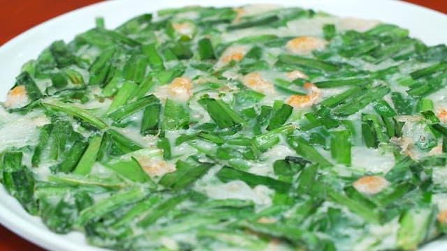 Appetizing chive pancakes and pickled onions on the table