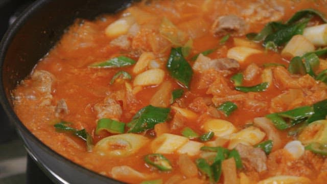 Pot of kimchi stew boiling with flavorful ingredients