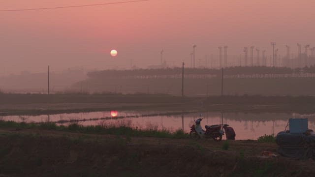 Sunset over a rural landscape with a motorcycle
