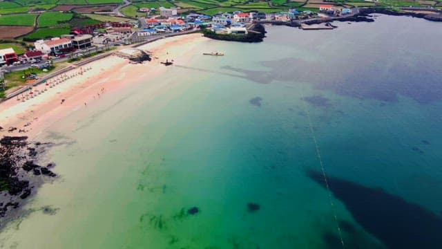Coastal town with colorful houses alongside the clear beach