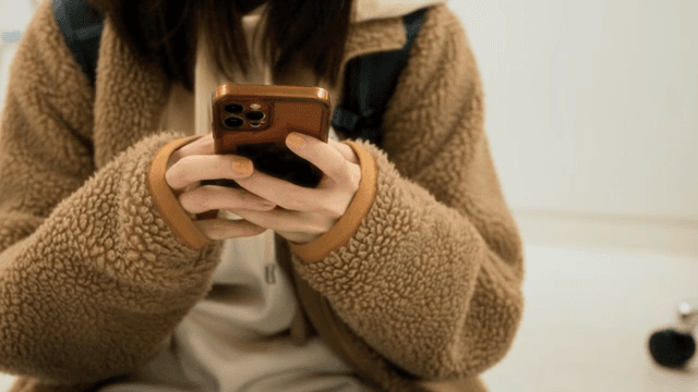 Person reaching for a smartphone on the floor
