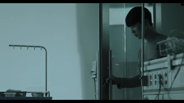 Man entering a hospital room, looking worried