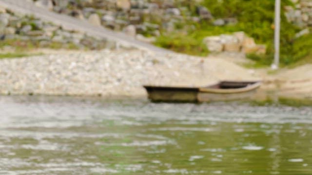 Wooden boat tied at the riverbank on a calm day