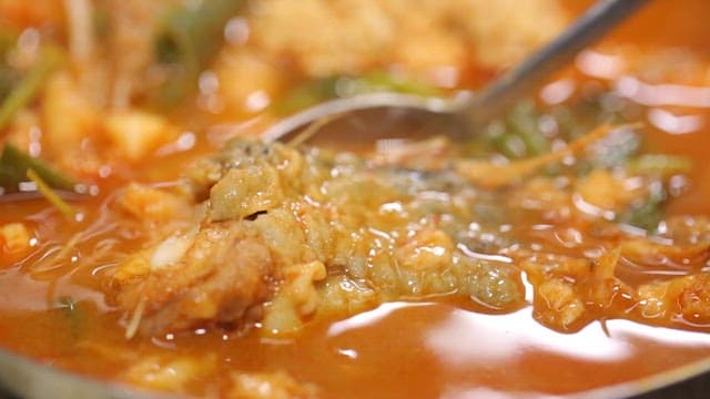 Spicy shaggy sea raven stew with a spoon