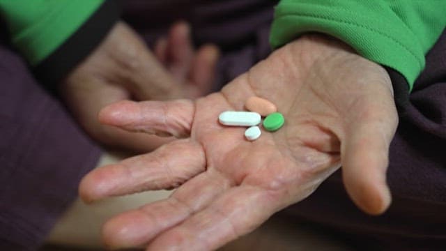 Elderly Person Holding Prescription Pills