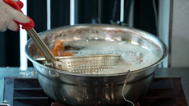Frying food in hot oil indoors