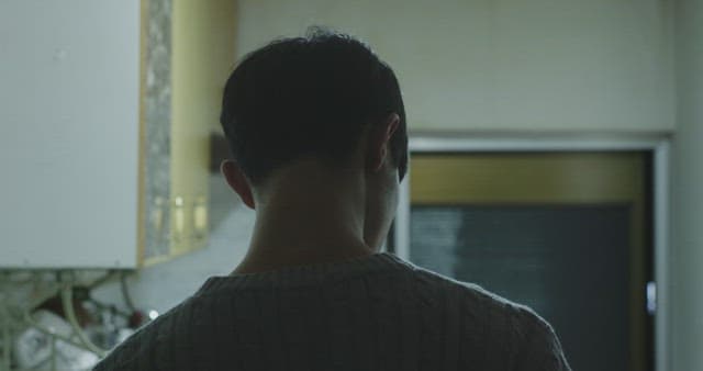 Man in the kitchen alone talking on his cell phone