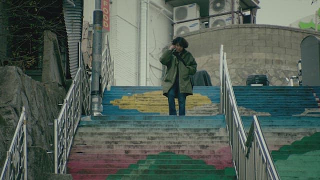 Person walking down colorful stairs while talking on the phone