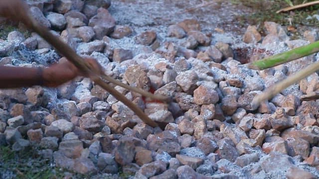 People arranging stones to make fire