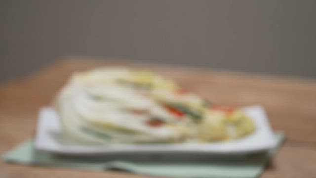 Fresh cabbage kimchi on a plate on a wooden table
