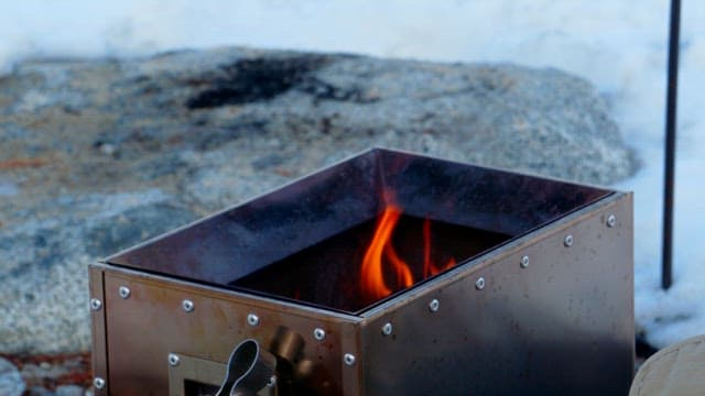 Frying pan placed on a metal brazier with flames