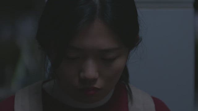 Woman turning on the light with a lighter in a dark room