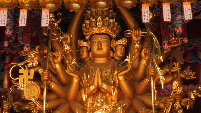 Golden Buddhist statue with multiple arms