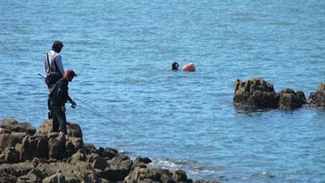 Fishermen on Rocks and Woman Divers in the Sea