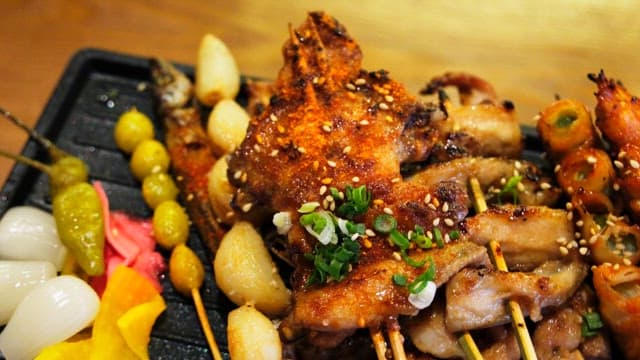 Various types of grilled skewers neatly arranged on an iron plate