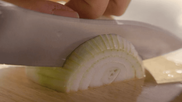 Slicing a Fresh Onion on a Wooden Board
