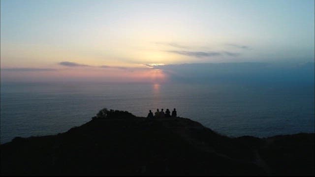 Group Watching Sunrise by the Sea