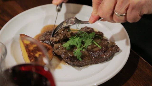 Cutting a luxuriously plated steak with a knife