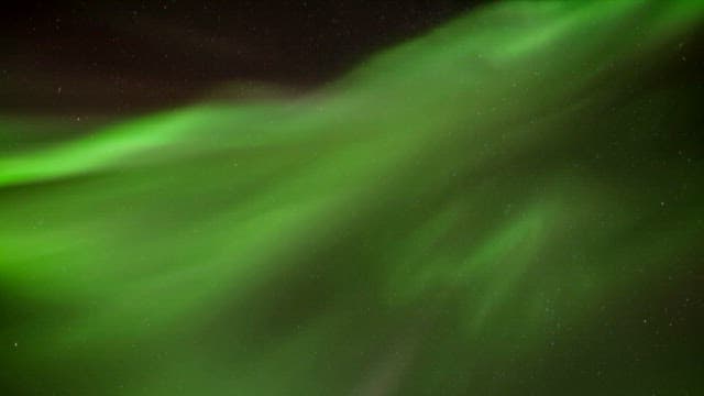 Green aurora glowing in the night sky