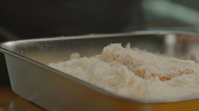 Coating pork in frying powder and flour in the kitchen tray