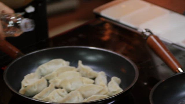 Cooking dumplings in a frying pan with water