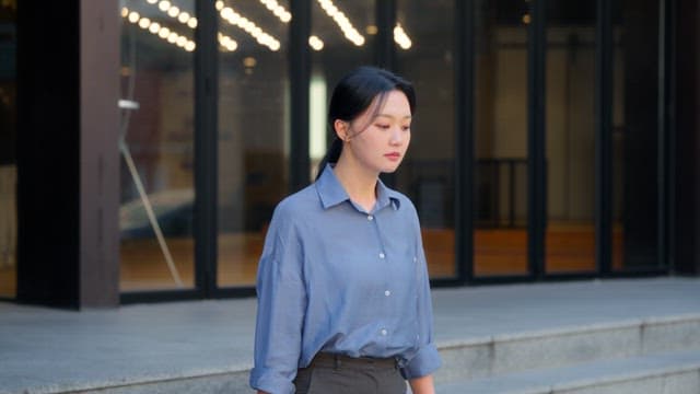 Woman looking up outside a building
