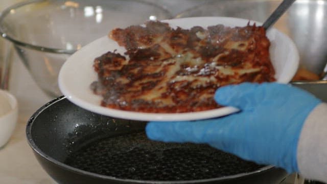 Placing freshly cooked pancake on a plate