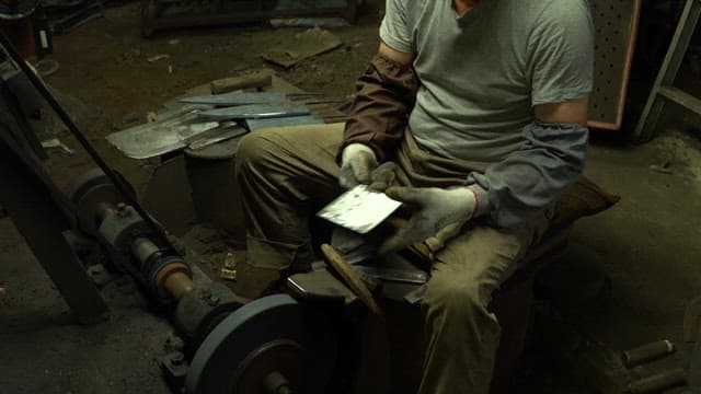 Worker sharpening a knife in a workshop