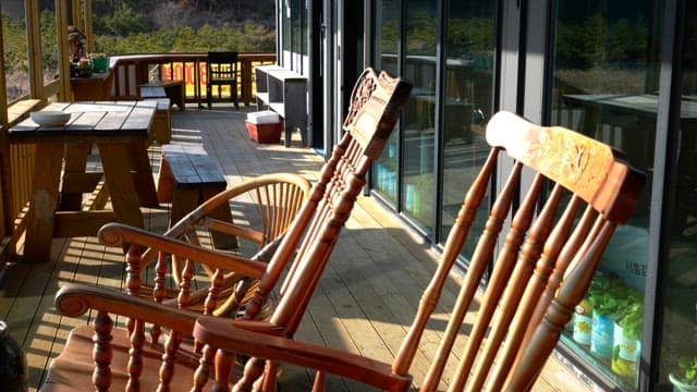 Beautiful verandah with wooden chairs and tables in the sunshine