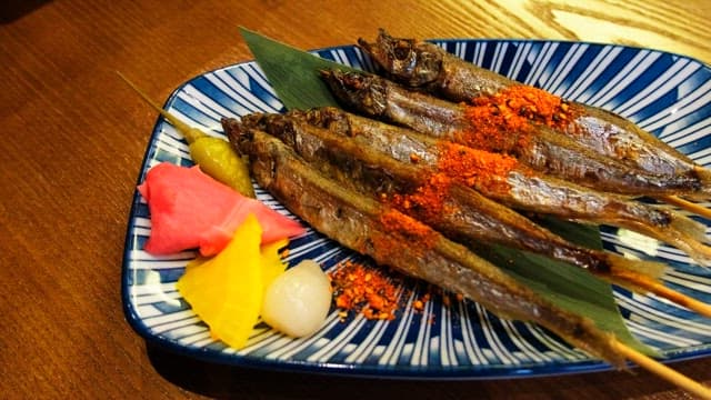 Grilled shisamo skewers neatly placed on a plate