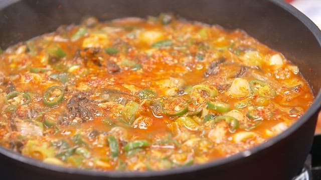 Appetizing braised mackerel with dried radish greens simmering in a pot