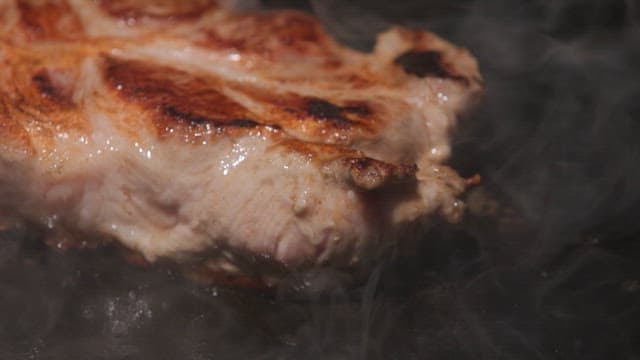 Juicy pork shoulder sizzling on a hot grill