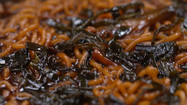 Glossy surface of Jjajang Ramen with green onions