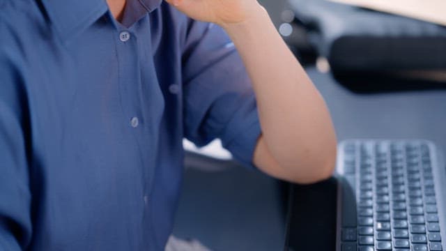 Person typing on a keyboard in an office