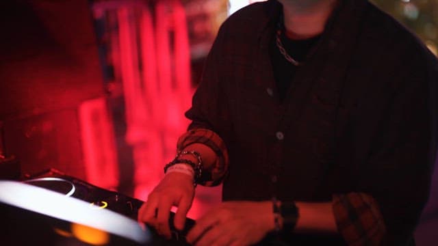 DJ Performing in a Club with Dazzling Psych Lighting