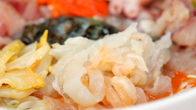 Picking up fresh cold raw fish soup using chopsticks