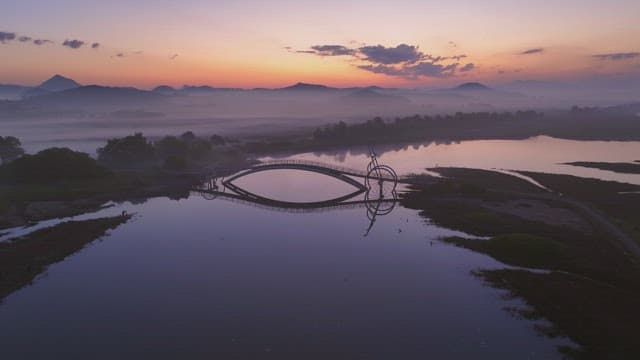 Serene river with misty mountain at sunset