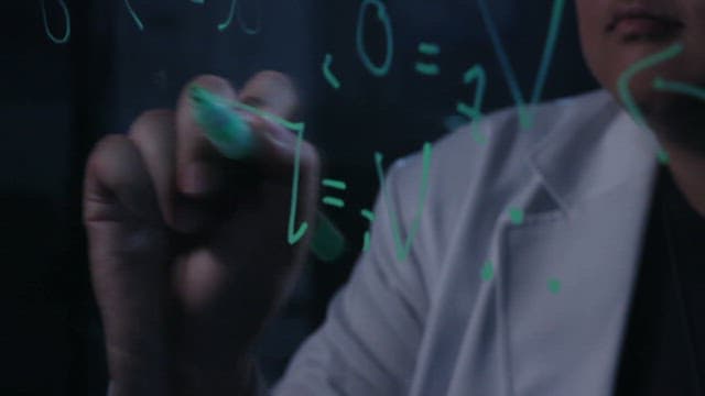 Researcher writing equations on a transparent board