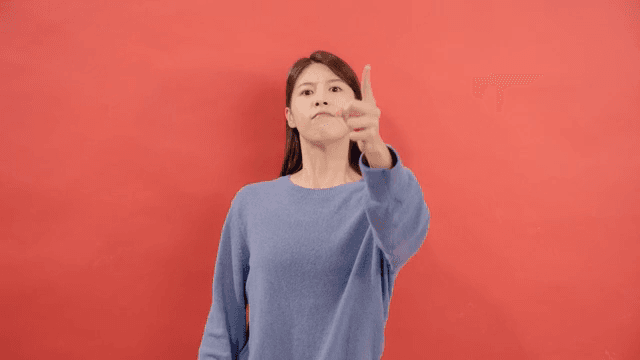 Woman expressing her anger by pointing her finger with a serious expression