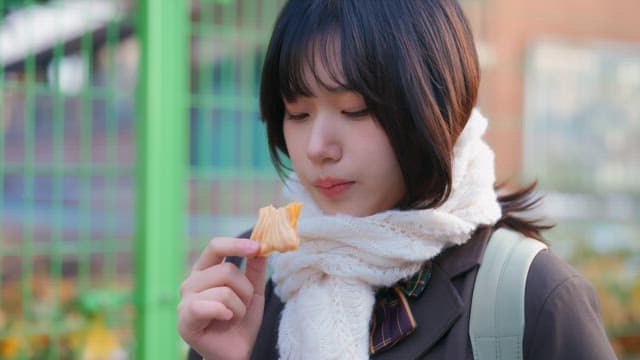 Student eating bungeoppang in winter