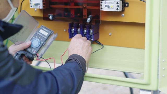 Technician Measuring Electrical Equipment
