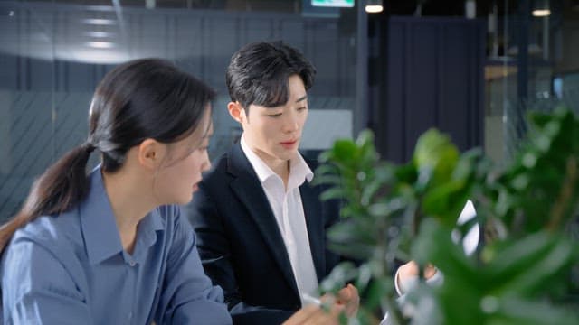 Two colleagues discussing work at a desk