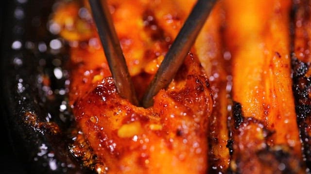 Spicy seasoned grilled deodeok cooked on a hot iron plate