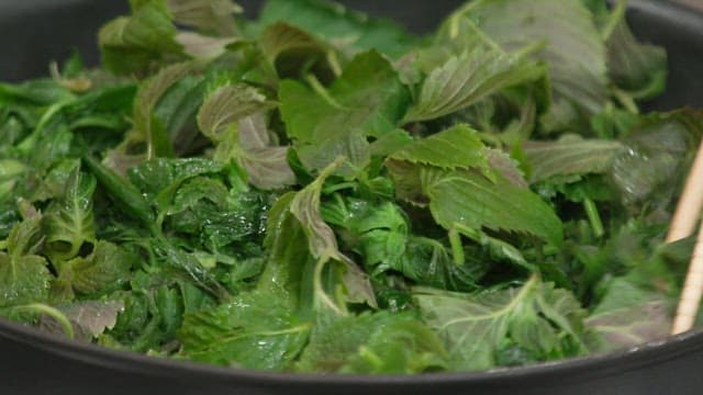Parboiling perilla leaves in a pan with chopsticks